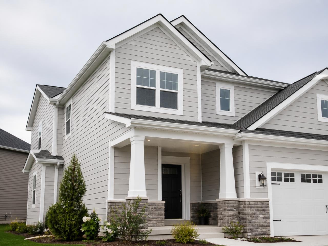 Newly installed light gray fiber cement lap siding on a Michigan home